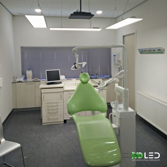 Behandelkamer bij de tandarts. De LED panelen zijn gependeld om de stoel in een U-vorm.